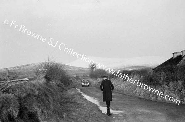 MAN WALKING ALONG ROAD